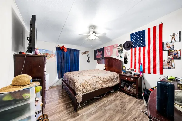 a bedroom with a bed and wooden floor