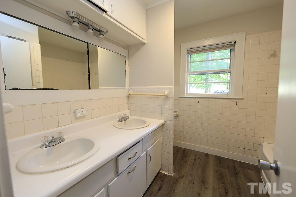 3644 Guess Road Durham, NC 27705 - Photo 5 of 14 The bathroom features a dual vanity, new flooring and a re-glazed tub.