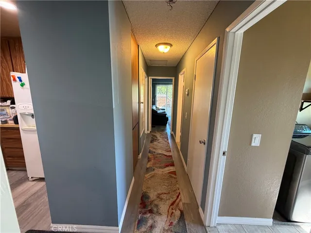 a view of a hallway with wooden floor and staircase
