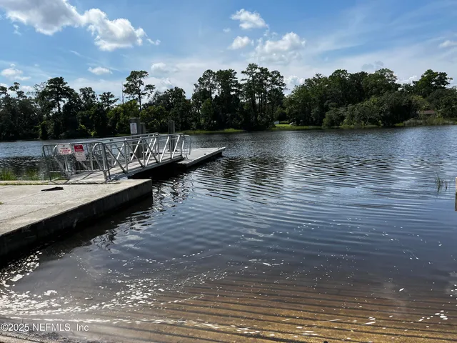 a view of a lake with boats and wooden fence