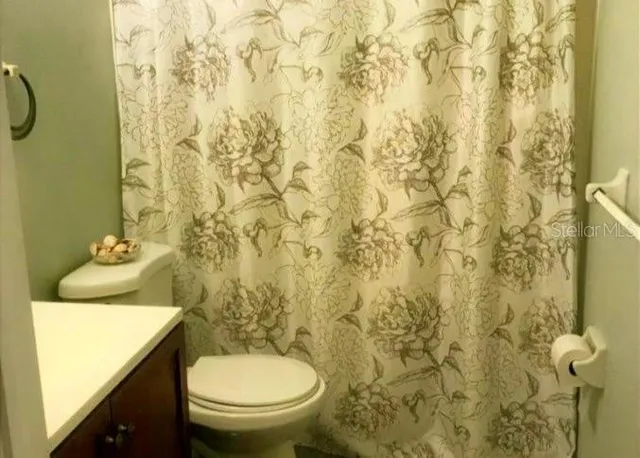 a bathroom with a granite countertop toilet and a sink