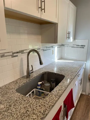 a kitchen with granite countertop a sink and a stove
