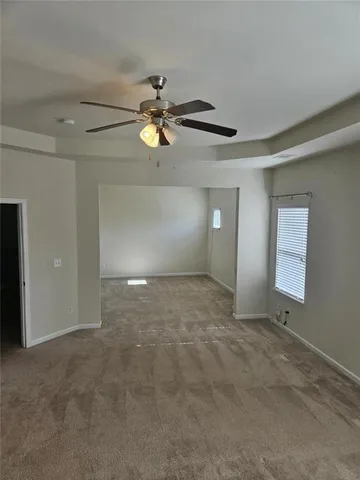 an empty room to ceiling fan and entryway