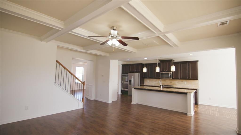 90 Partridge Drive Covington, GA 30016 - Photo 34 of 38 a view of an empty room and kitchen with wooden floor