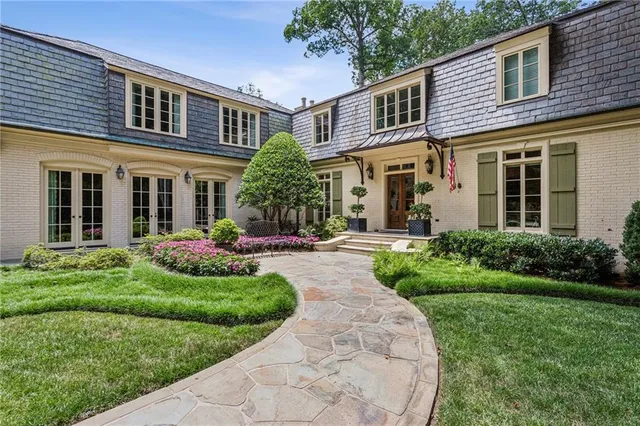 a front view of a house with a yard and potted plants
