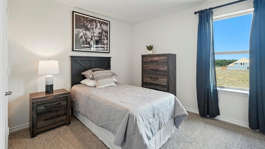 2640 Gladewater Road Celina, TX 75009 - Photo 8 of 40 a bedroom with a bed and a lamp on dresser