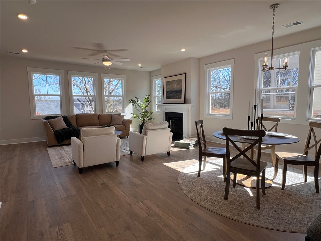 130 Tiger Lily Drive Anderson, SC 29621 - Photo 7 of 27 Bright and open living area features a dining space and a cozy fireplace, perfect for gatherings.