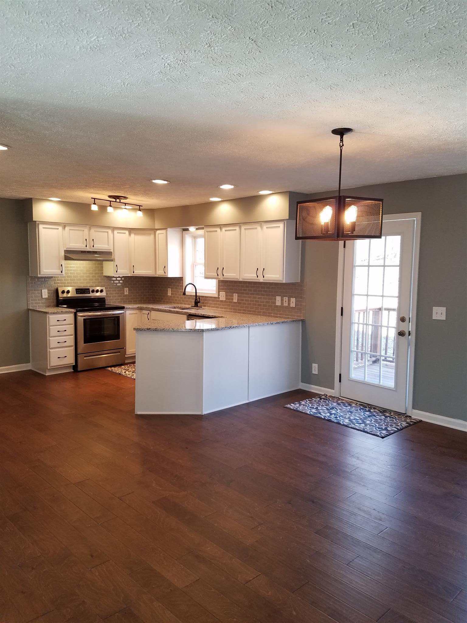 1300 Glendale Road Dickson, TN 37055 - Photo 11 of 30 a large kitchen with granite countertop a stove top oven a sink a counter space and cabinets