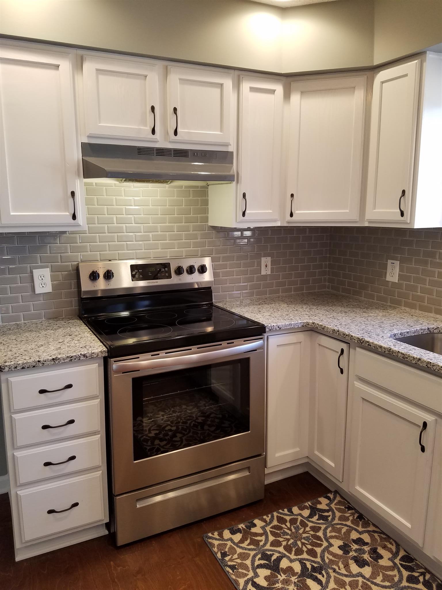1300 Glendale Road Dickson, TN 37055 - Photo 12 of 30 a kitchen with granite countertop white cabinets and stainless steel appliances