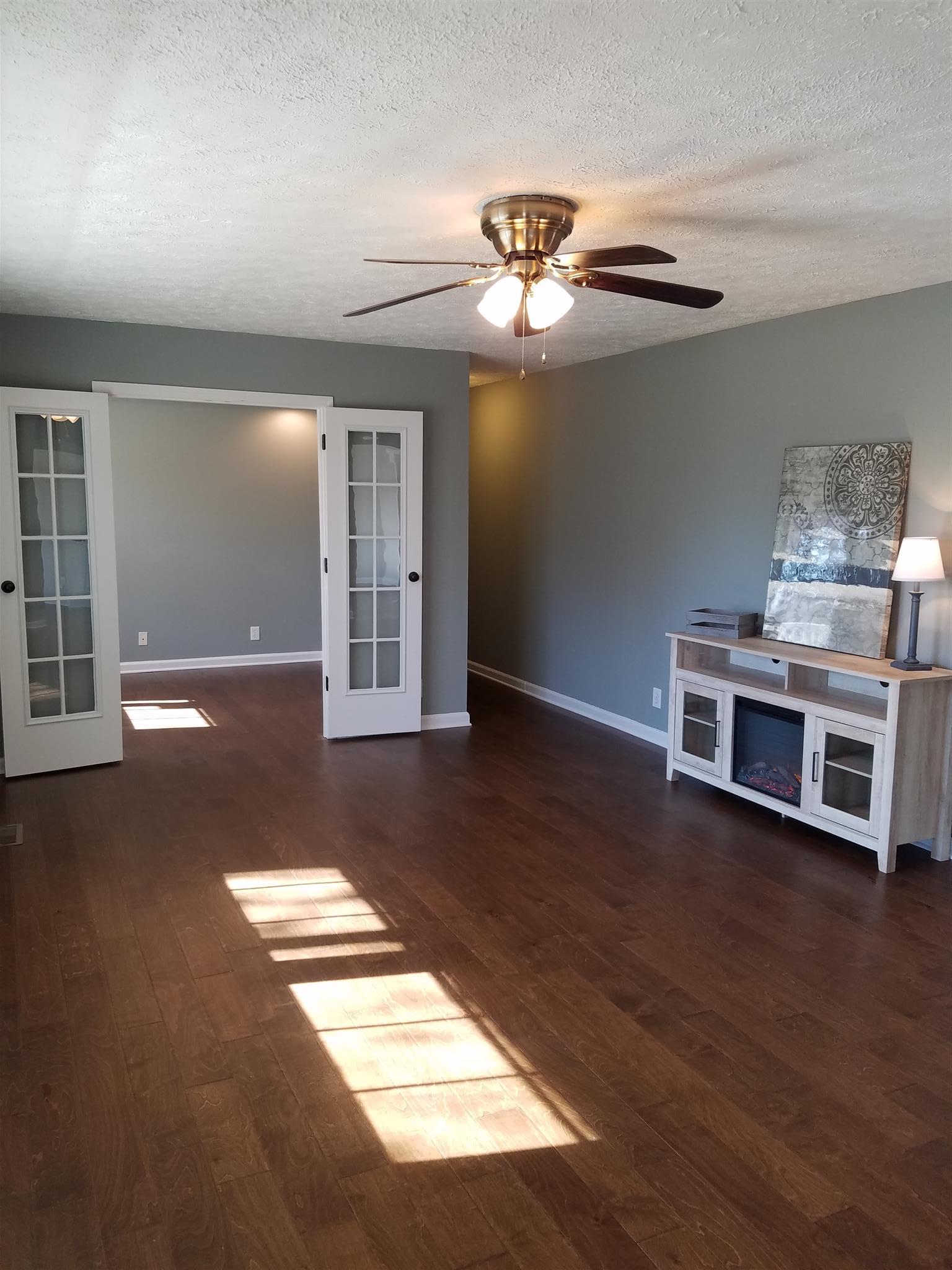 1300 Glendale Road Dickson, TN 37055 - Photo 15 of 30 a view of a livingroom with wooden floor a ceiling fan and windows
