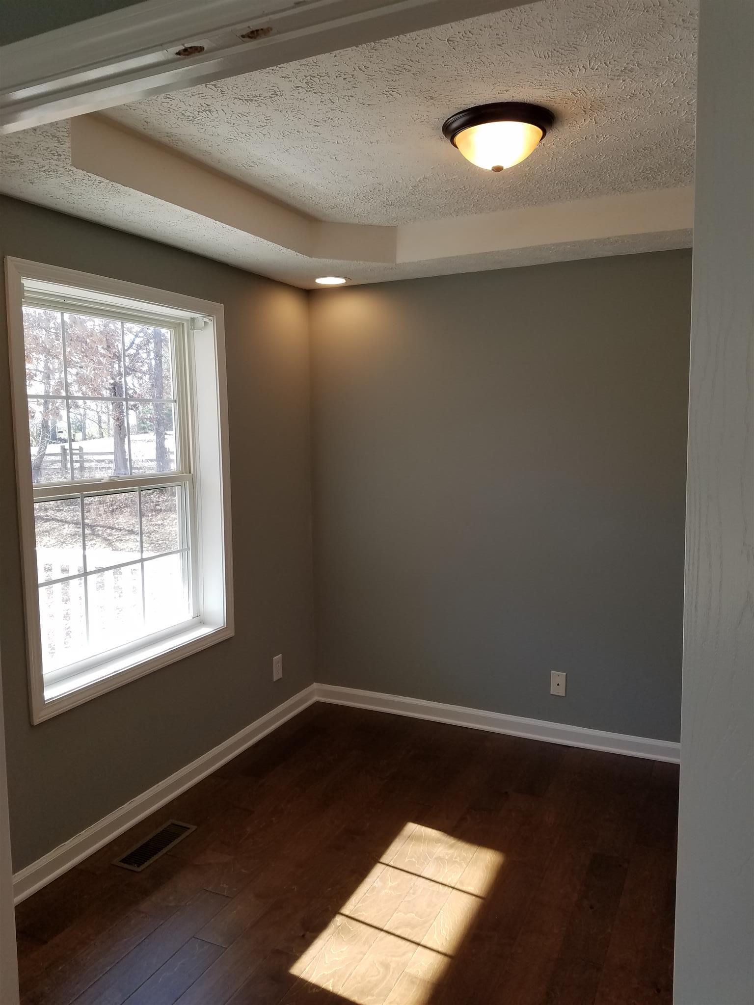 1300 Glendale Road Dickson, TN 37055 - Photo 18 of 30 an empty room with wooden floor and windows
