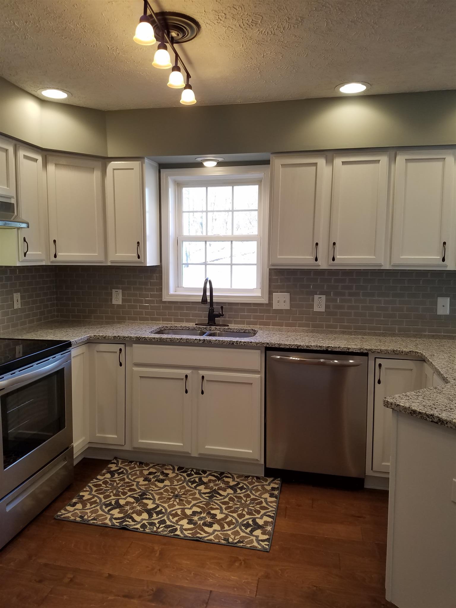 1300 Glendale Road Dickson, TN 37055 - Photo 4 of 30 a kitchen with granite countertop a sink stainless steel appliances and cabinets