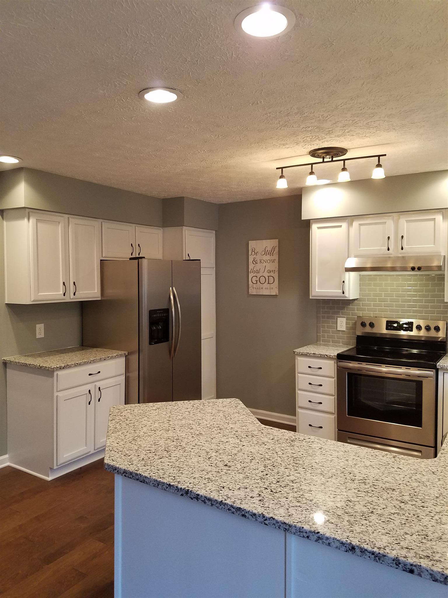 1300 Glendale Road Dickson, TN 37055 - Photo 6 of 30 a kitchen with stainless steel appliances granite countertop a stove a sink and a refrigerator