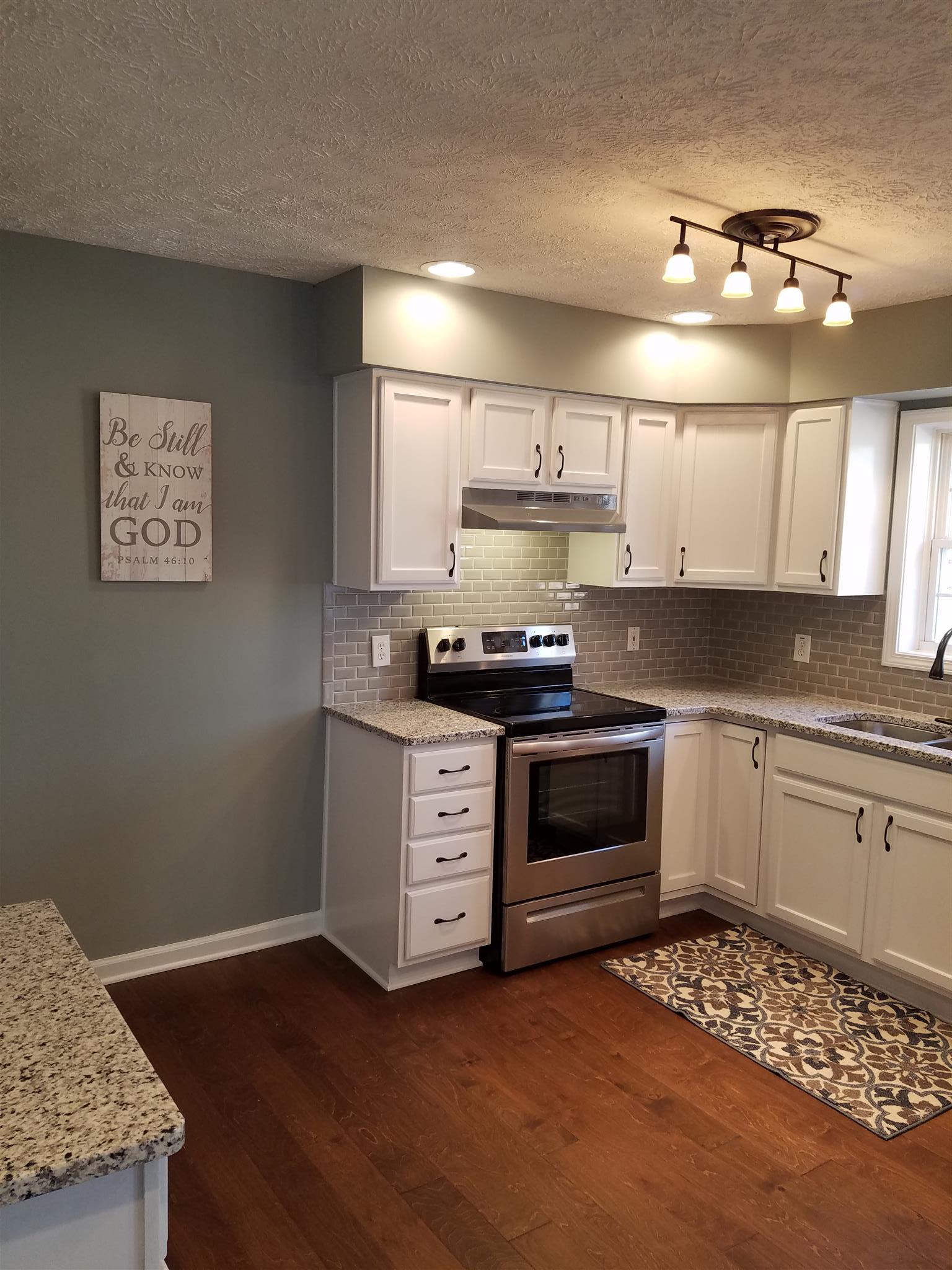 1300 Glendale Road Dickson, TN 37055 - Photo 8 of 30 a kitchen with a stove and white cabinets