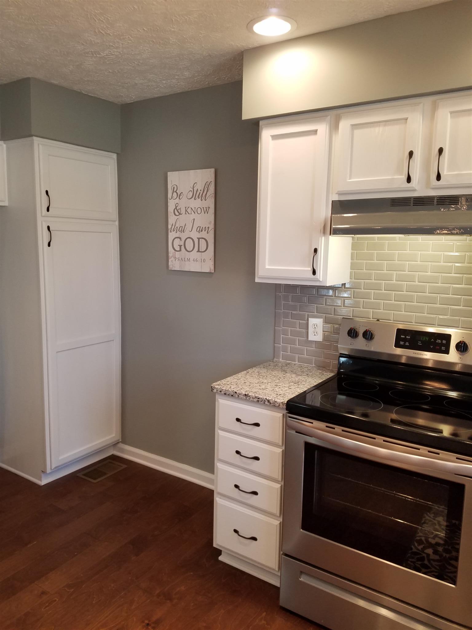 1300 Glendale Road Dickson, TN 37055 - Photo 9 of 30 a kitchen with granite countertop cabinets stainless steel appliances and wooden floor