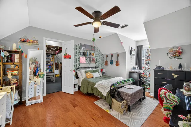 a bedroom with bed and wooden floor