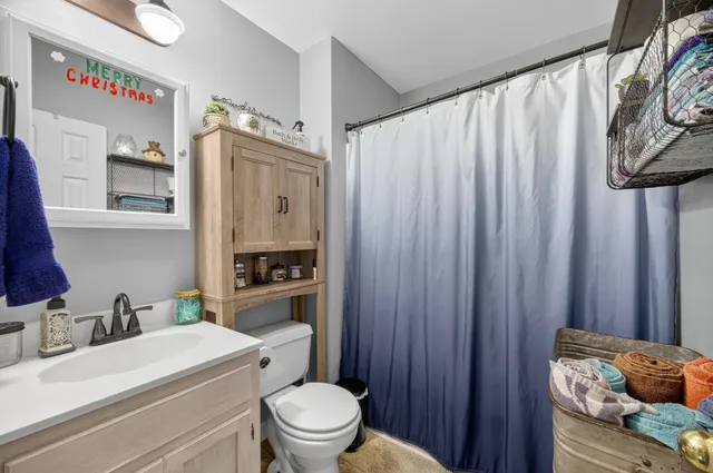 a bathroom with a sink a toilet and shower curtain