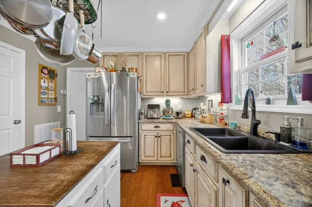 a kitchen with stainless steel appliances granite countertop a sink a stove and refrigerator