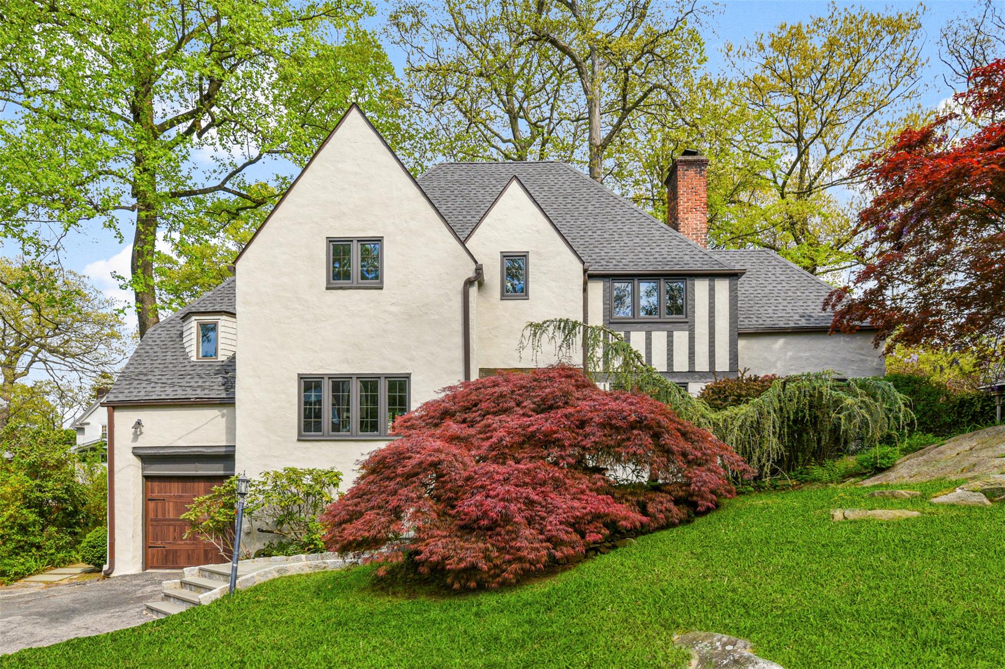 a front view of a house with a garden and plants