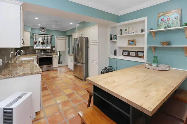 a living room with stainless steel appliances kitchen island granite countertop a rug and a view of kitchen