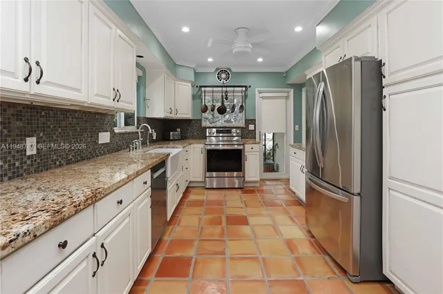 a large kitchen with stainless steel appliances granite countertop a refrigerator and a sink