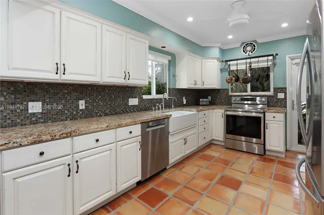 a kitchen with stainless steel appliances granite countertop a stove a sink and a refrigerator