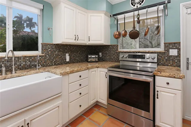 a kitchen with stainless steel appliances granite countertop a stove a sink and a microwave