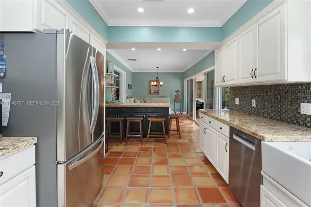 a kitchen with stainless steel appliances granite countertop a refrigerator and a stove top oven