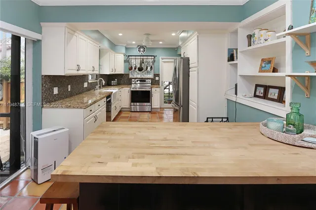 a kitchen with kitchen island a stove a refrigerator and a sink with wooden floor