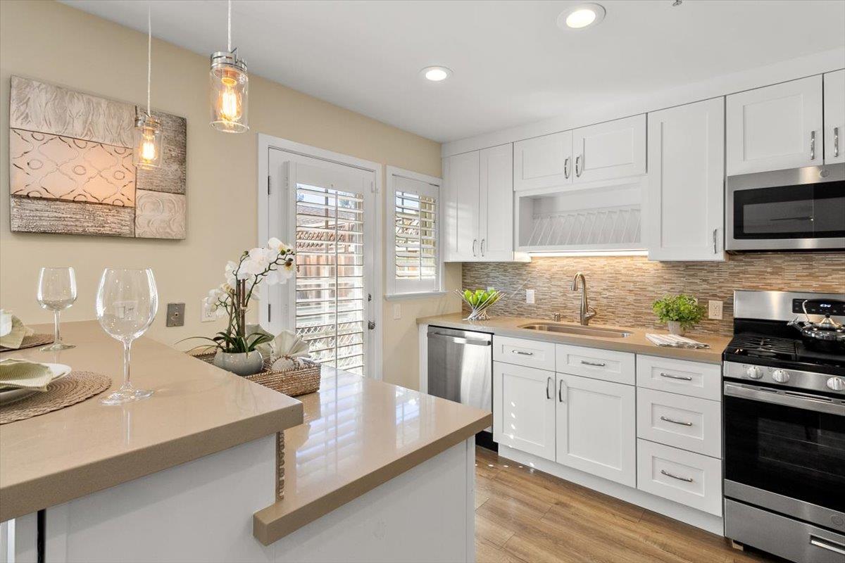 654 North San Antonio Road Los Altos, CA 94022 - Photo 20 of 28 a kitchen with kitchen island granite countertop a sink appliances cabinets and a counter top space