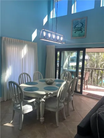 a view of a dining room with furniture large windows and wooden floor