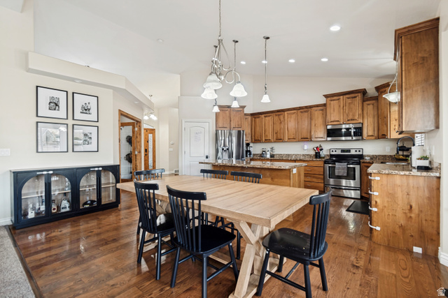7296 Ridge Road Lake Point, UT 84074 - Photo 13 of 54 Open-concept kitchen and dining area featuring wood-finish flooring, recessed lighting, and a vaulted ceiling
