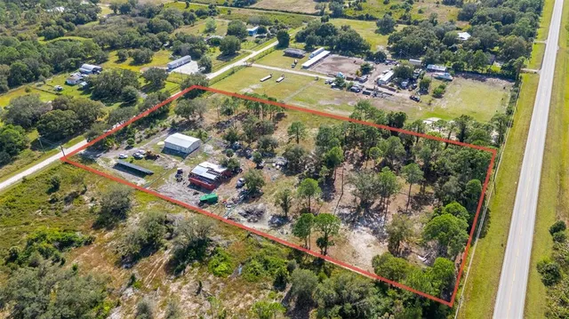 an aerial view of residential house with outdoor space and trees