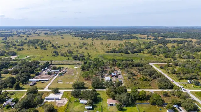 an aerial view of residential houses with outdoor space and trees