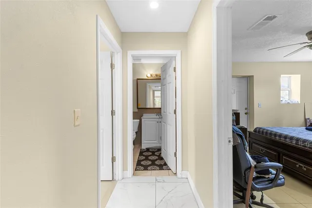 a view of a hallway and a livingroom with furniture