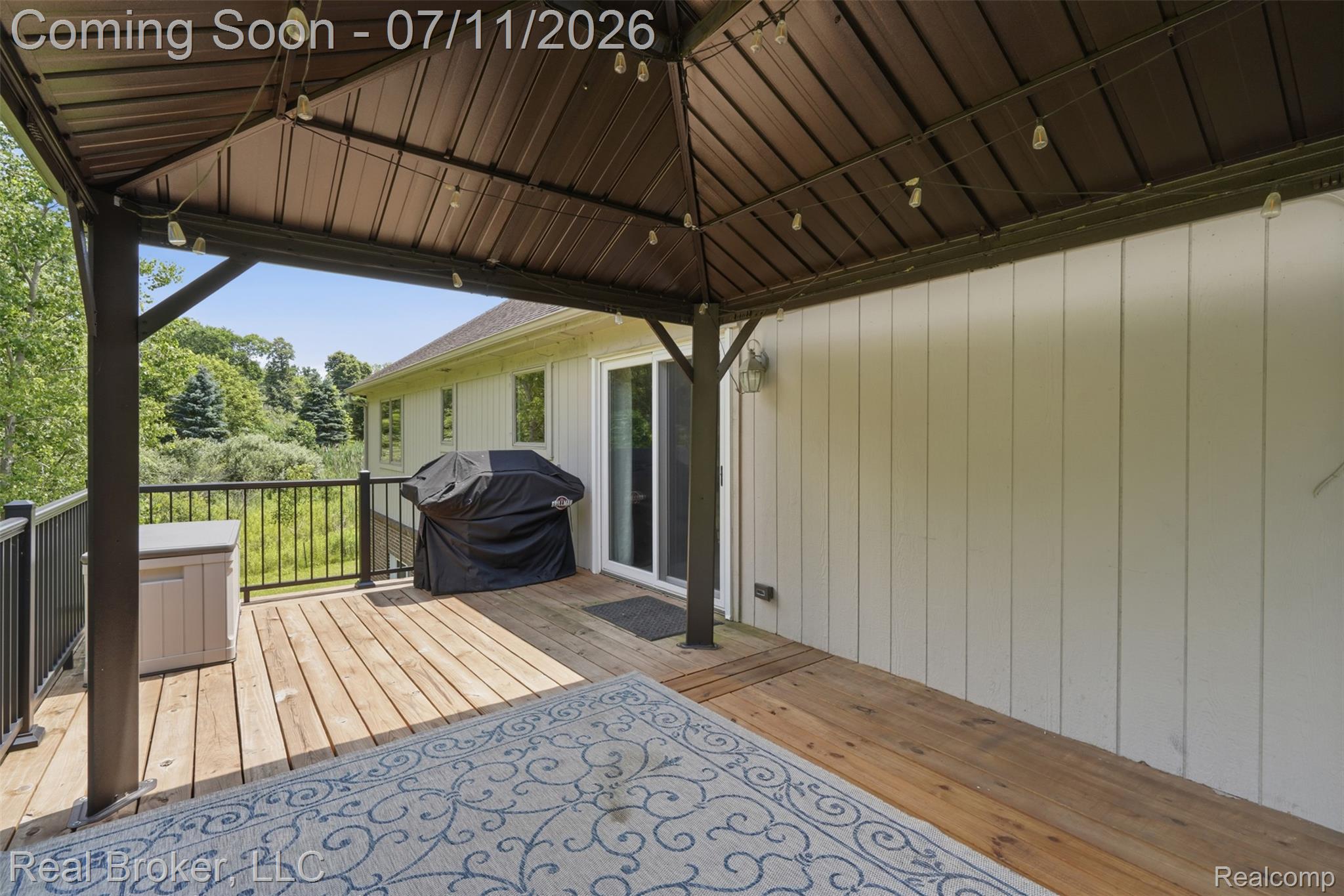 1050 West Brocker Road Metamora, MI 48455 - Photo 37 of 55 Deck featuring a brown metal gazebo with string lighting, wood plank flooring, and black metal railings