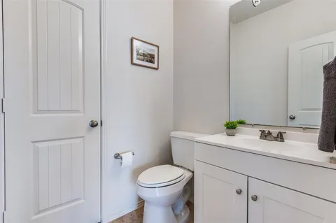 a bathroom with a granite countertop toilet sink and mirror