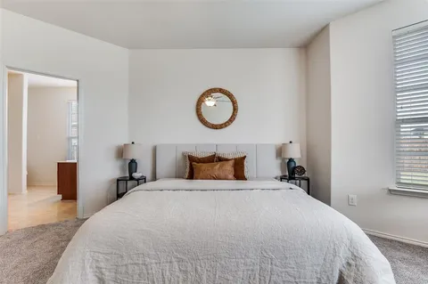 a bedroom with a large bed and a window