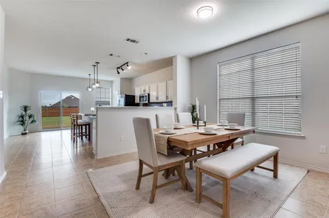 a dining room with a wooden table and chairs