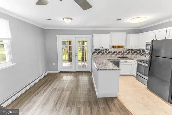 a kitchen with a refrigerator and wooden floor