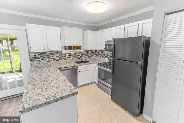 a kitchen with a refrigerator sink and cabinets