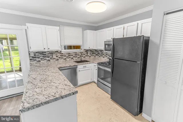 a kitchen with a refrigerator sink and cabinets