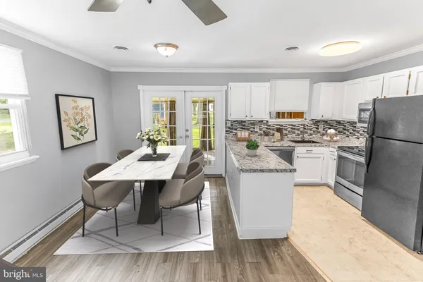 a kitchen with a dining table chairs and refrigerator