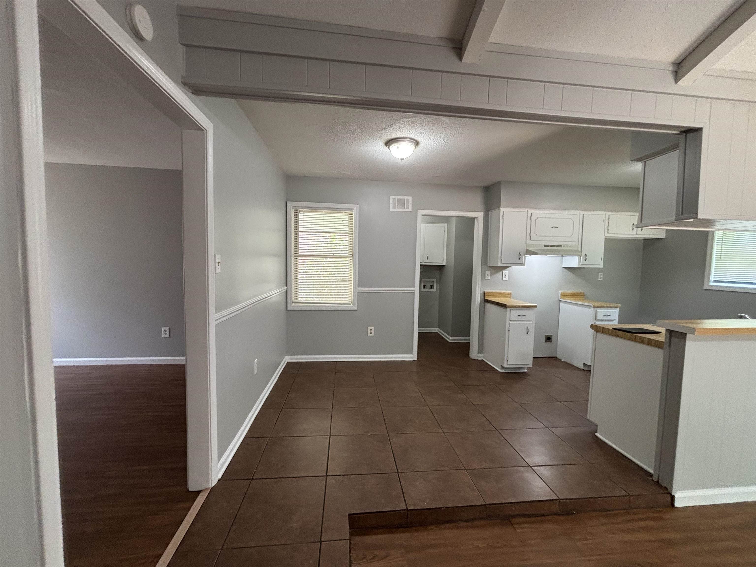 4040 Windermere Road Memphis, TN 38128 - Photo 12 of 14 Kitchen with white cabinets, dark wood-style floors, a textured ceiling, light countertops, and beamed ceiling