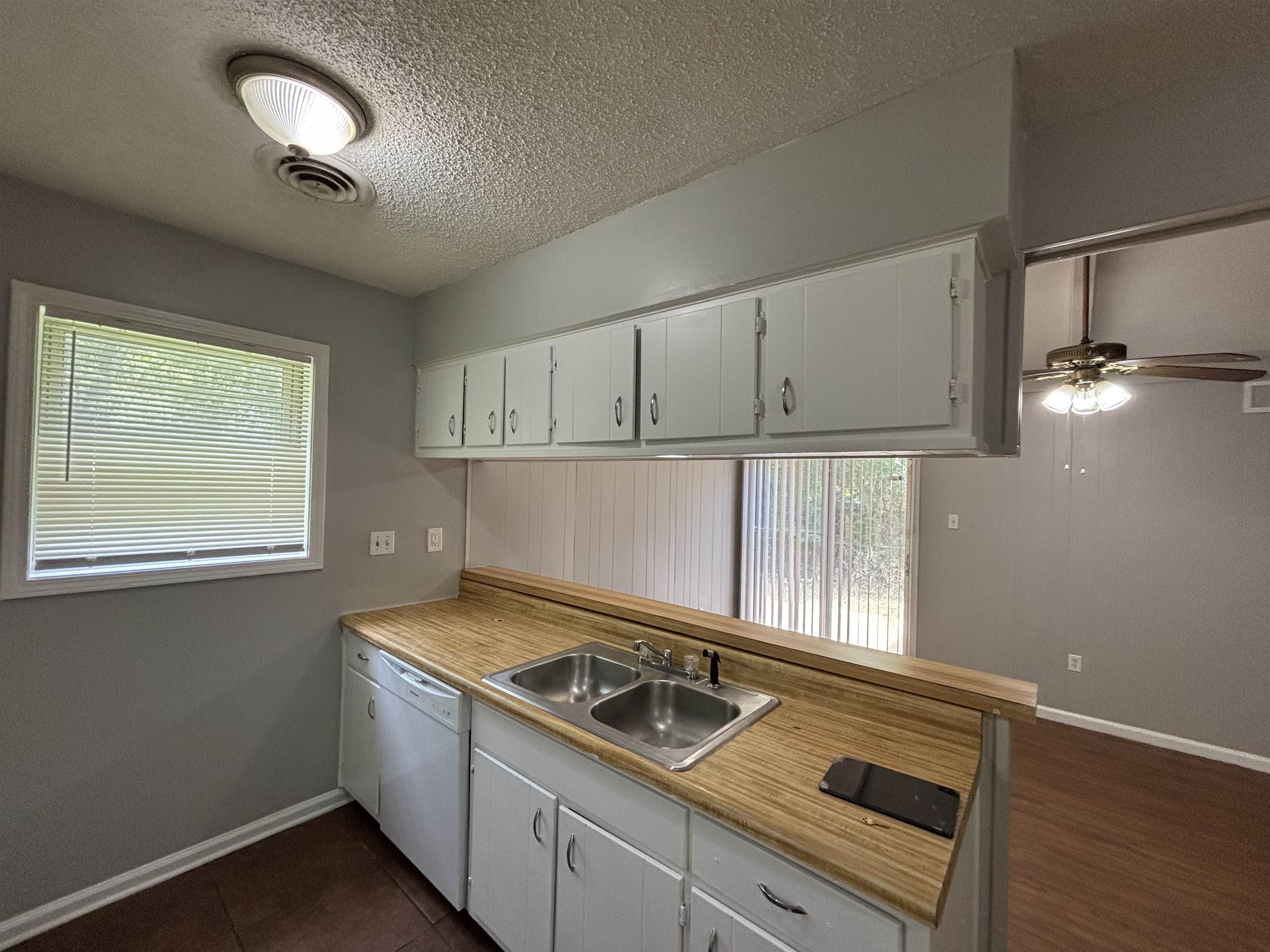 4040 Windermere Road Memphis, TN 38128 - Photo 13 of 14 Kitchen featuring white cabinetry, light countertops, dishwasher, a textured ceiling, and a ceiling fan