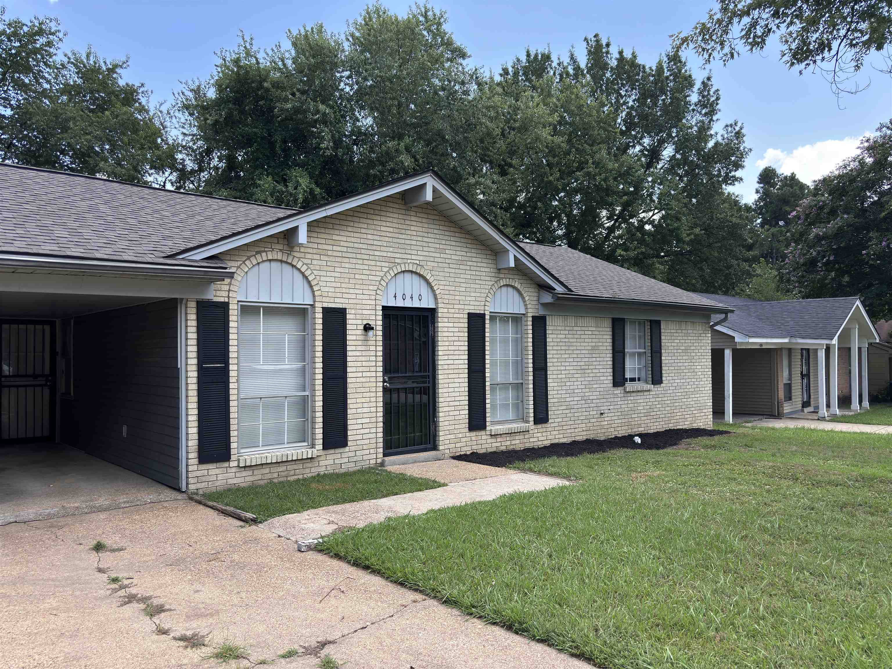 4040 Windermere Road Memphis, TN 38128 - Photo 2 of 14 Ranch-style home with brick siding, a front lawn, roof with shingles, and concrete driveway