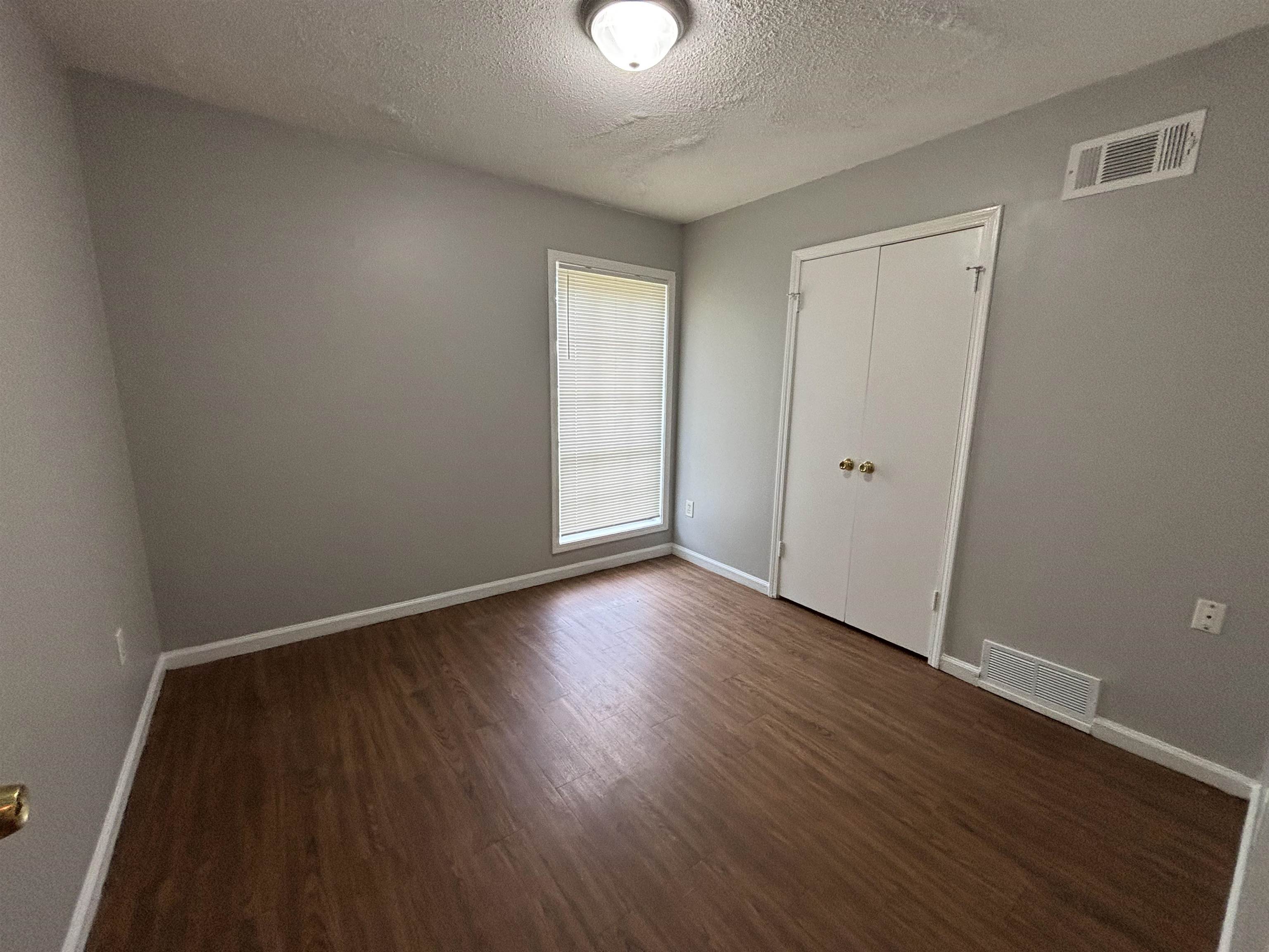 4040 Windermere Road Memphis, TN 38128 - Photo 6 of 14 Unfurnished bedroom with dark wood finished floors, a textured ceiling, and a closet