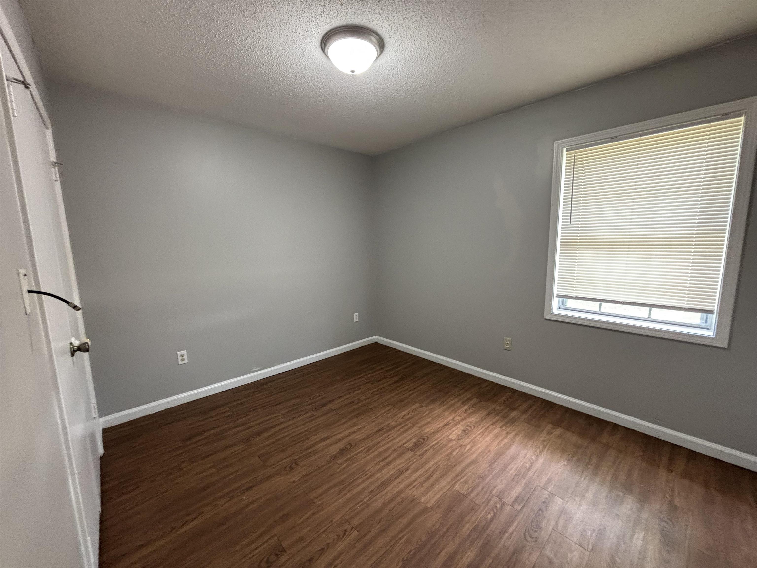 4040 Windermere Road Memphis, TN 38128 - Photo 7 of 14 Empty room featuring a textured ceiling and dark wood-style flooring