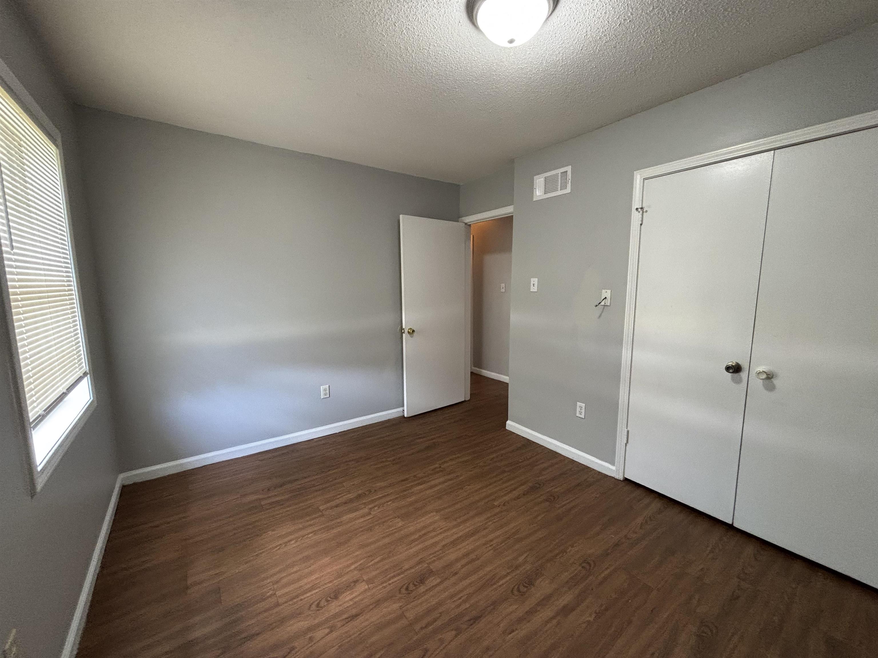 4040 Windermere Road Memphis, TN 38128 - Photo 8 of 14 Unfurnished bedroom with dark wood-type flooring, a textured ceiling, and a closet