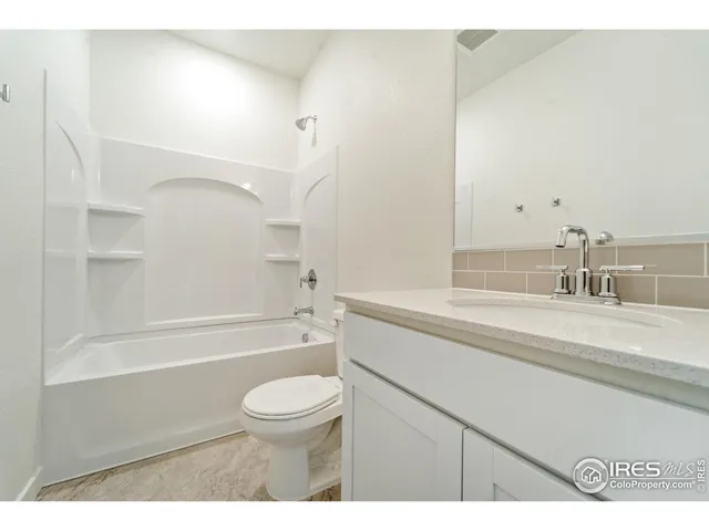 a bathroom with a granite countertop sink a toilet and shower
